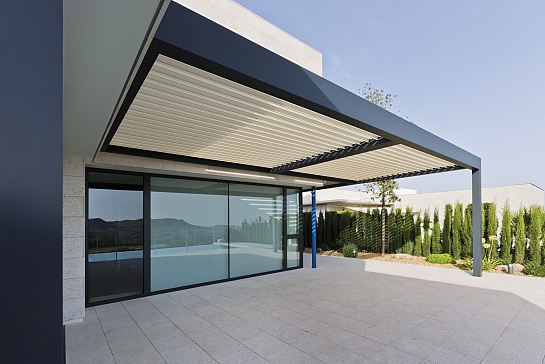 PÉRGOLA BIOCLIMÁTICA PROTEGIENDO LA TERRAZA DE UNA VIVIENDA EN URBANIZACIÓN DE LUJO