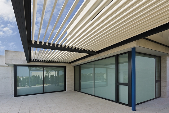PÉRGOLA BIOCLIMÁTICA PROTEGIENDO LA TERRAZA DE UNA VIVIENDA EN URBANIZACIÓN DE LUJO